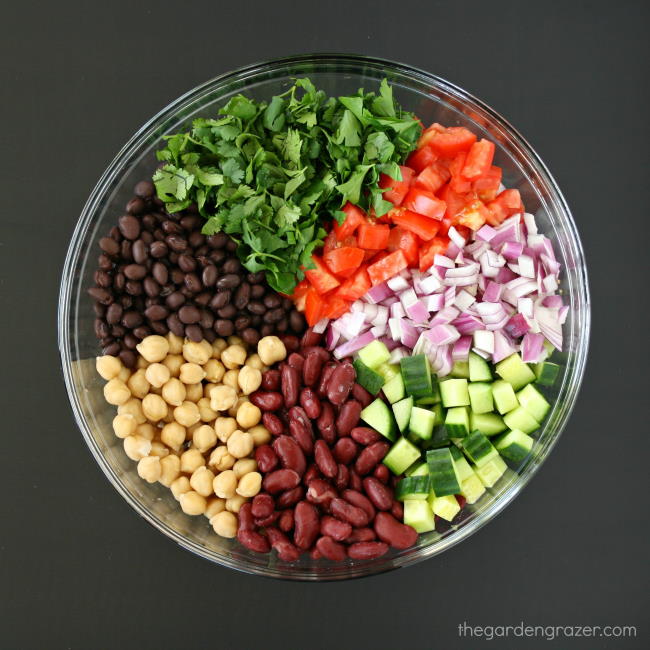 Ingredients for three bean salad in a glass bowl before mixing