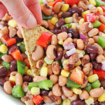 Tortilla chip dipping into a bowl of cowboy caviar