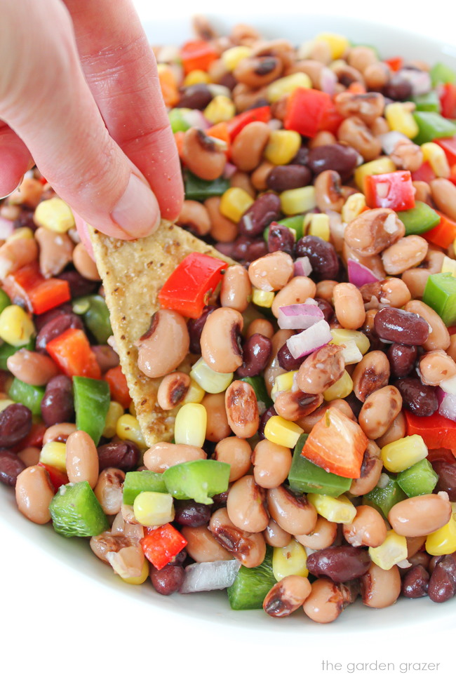 Tortilla chip dipping into a bowl of cowboy caviar