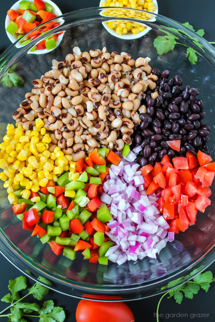 Overhead view of preparing vegan cowboy caviar in a large glass bowl before mixing together