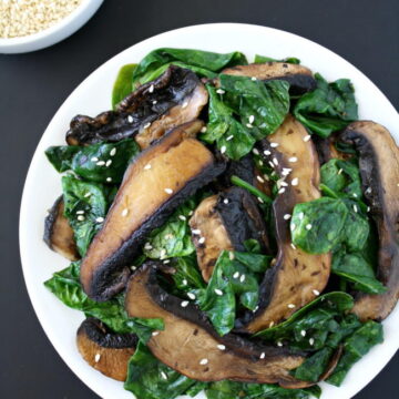 Portobello with spinach topped with sesame seeds on a plate