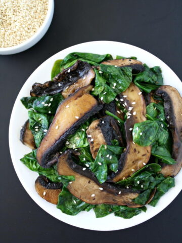 Portobello with spinach topped with sesame seeds on a plate