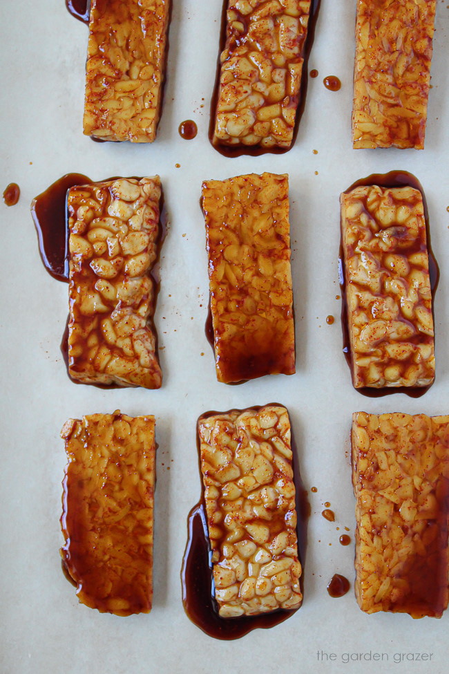 Prepared marinated tempeh slices on a sheet pan