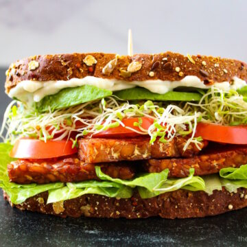 Side view of TLT tempeh sandwich with sprouts and avocado