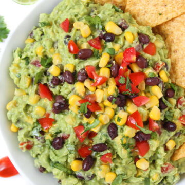 Black bean corn guacamole in a bowl with chips on the side