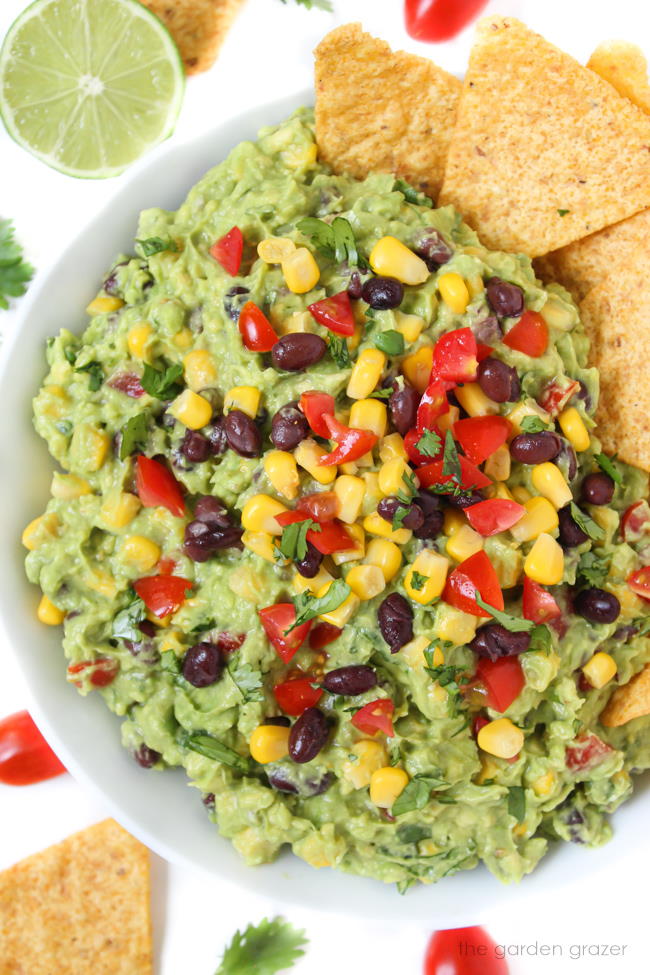 Black bean corn guacamole in a bowl with chips on the side