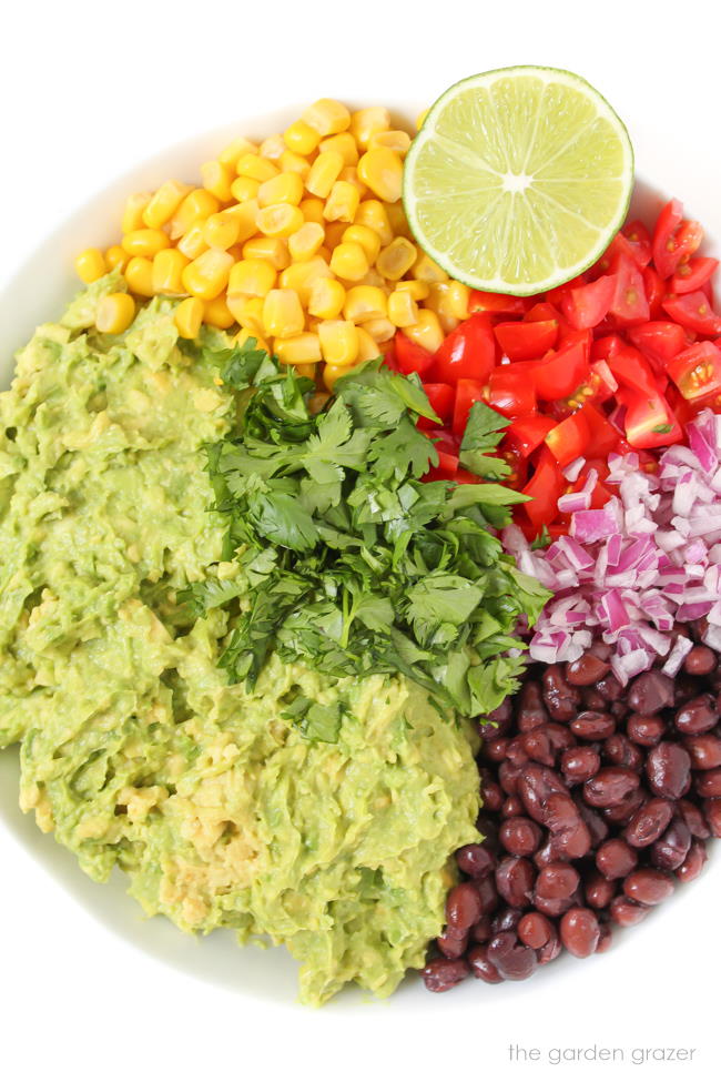 Preparing and combining guacamole ingredients in a white bowl