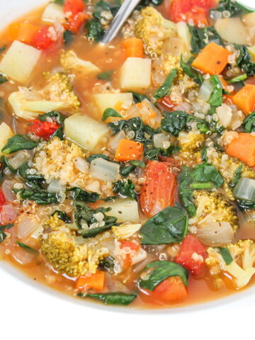 Quinoa potato soup with spinach, kale, and broccoli in a white bowl