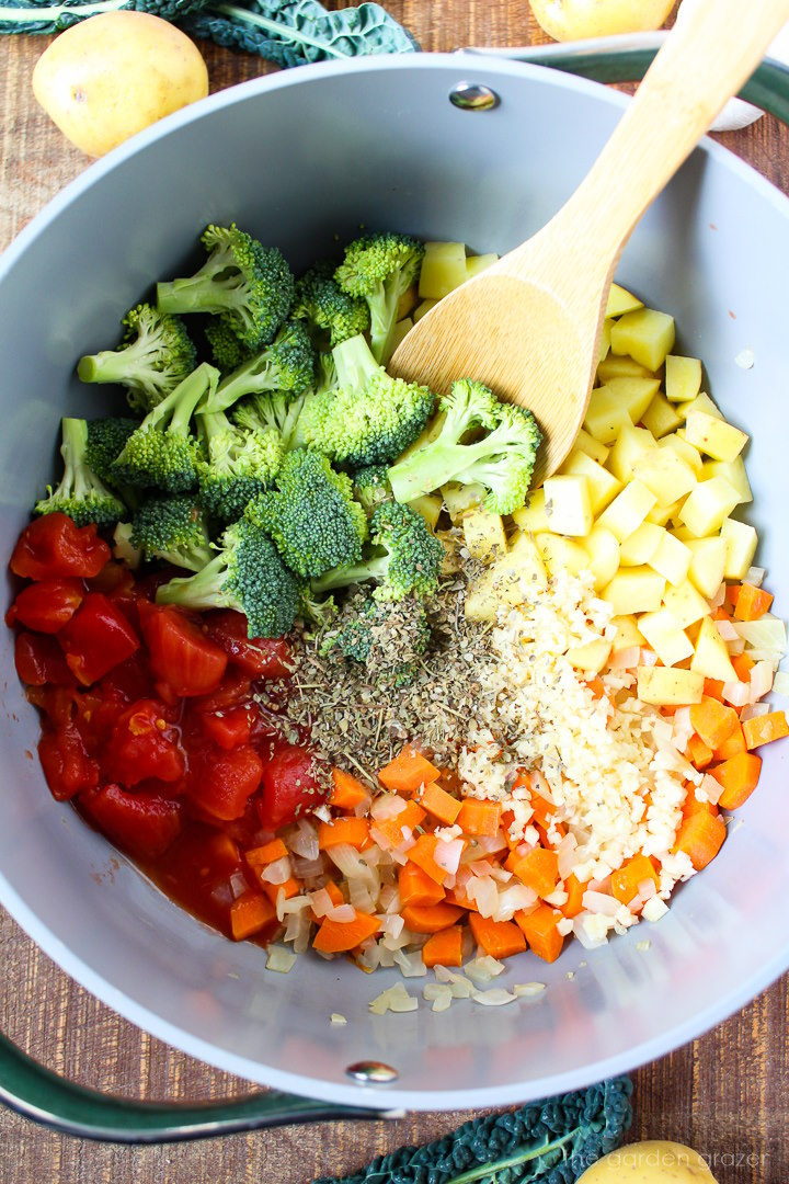 Overhead view of preparing quinoa potato soup ingredients in a large pot before mixing together