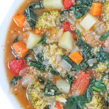 Vegan Quinoa Potato Soup with kale and spinach in a white bowl