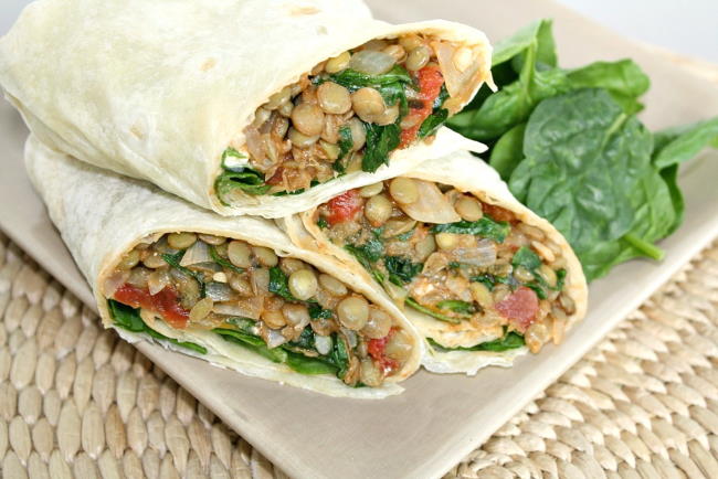 Lentil Spinach Burritos cut in half on a plate