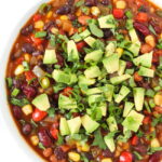 Three Bean Chili in a bowl topped with cilantro and avocado