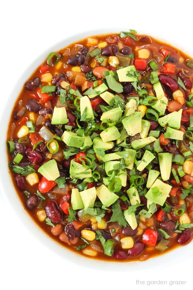 Three Bean Chili in a bowl topped with cilantro and avocado