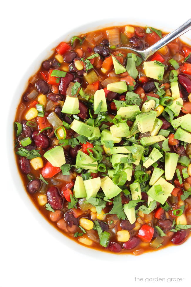 Bowl of Vegan Three Bean Chili topped with avocado and cilantro