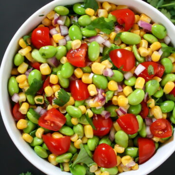 Bowl of edamame corn salad with tomato and cilantro