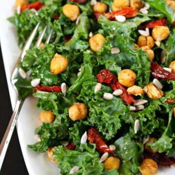 Kale salad with roasted chickpeas on a plate with fork