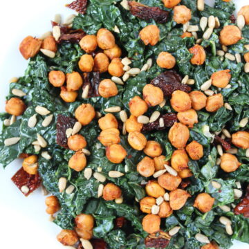 Roasted chickpea kale salad on a white plate with sun-dried tomatoes