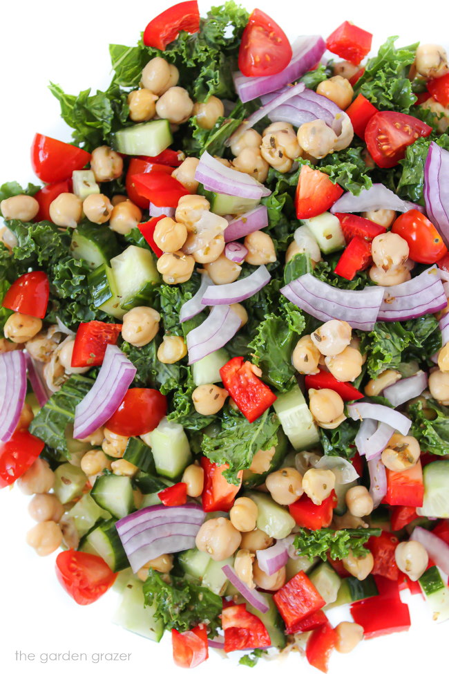 Greek kale salad with garbanzo beans in a large glass bowl