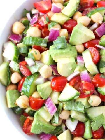 Vegan avocado tomato salad with cucumber in a bowl