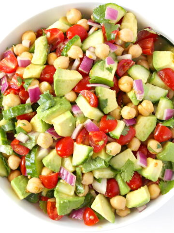 Avocado tomato chickpea salad in a white bowl