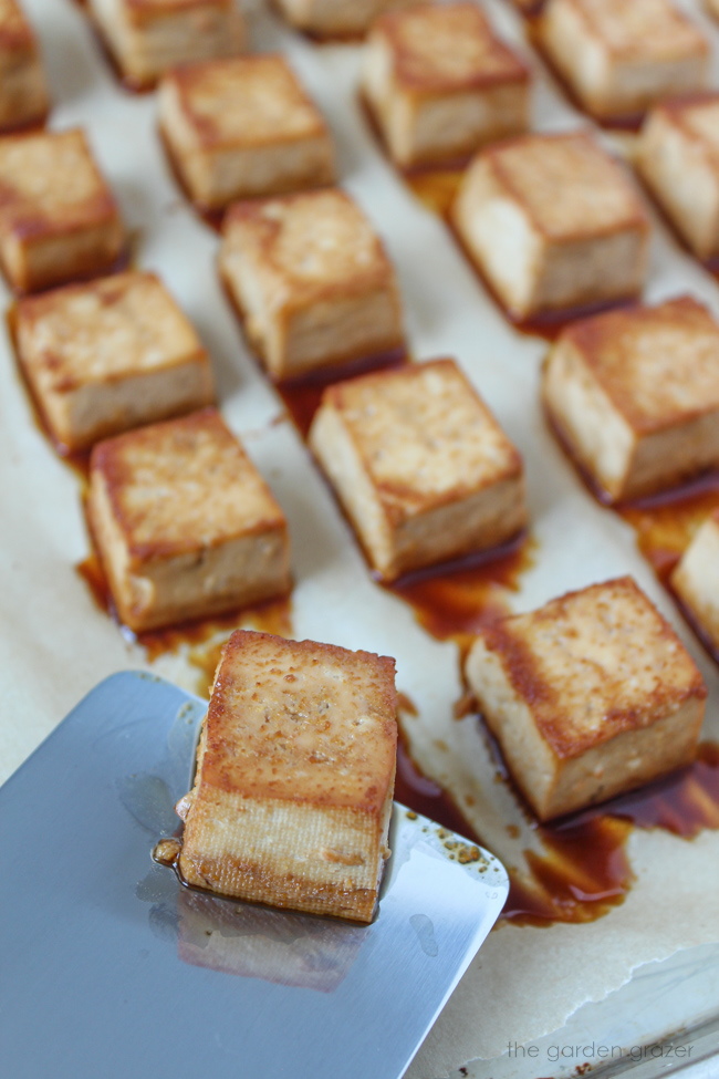 Baked tofu on a sheet pan with metal spatula