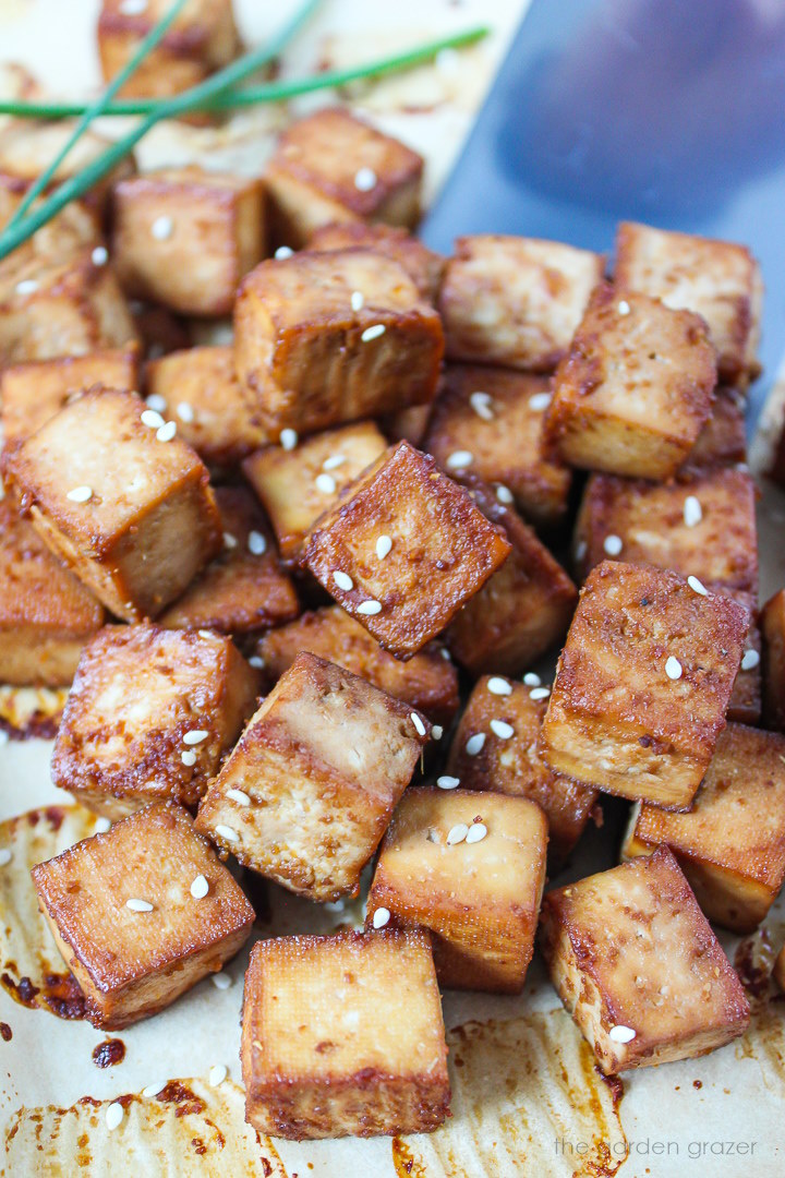 Easy savory baked tofu cubes roasting on a sheet pan with metal spatula