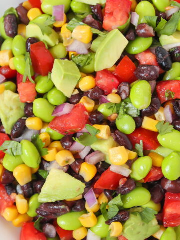 Avocado edamame black bean salad in a white bowl