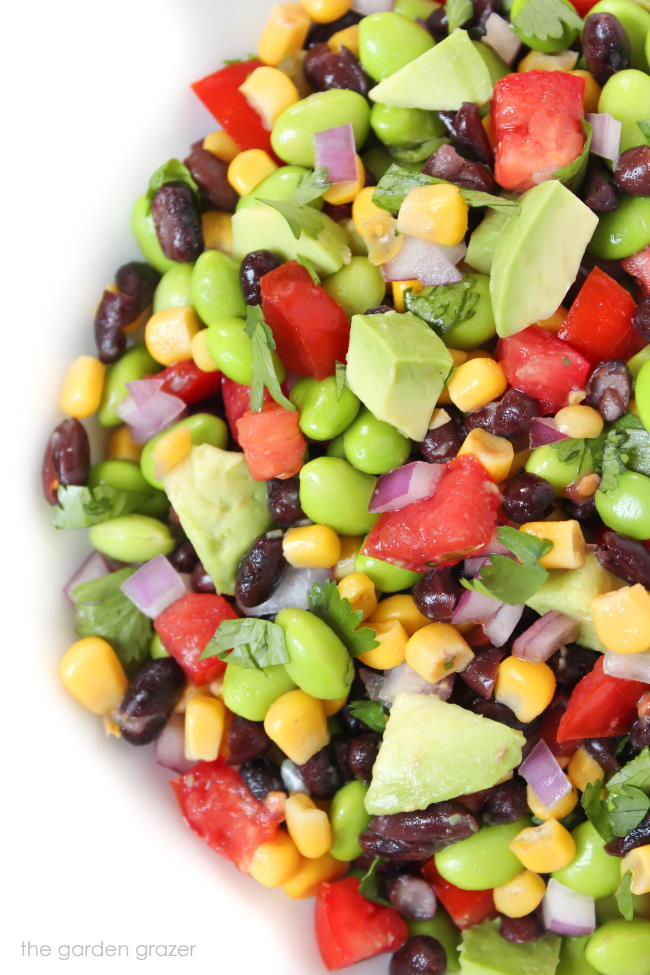 Avocado edamame salad with black beans and tomatoes in a bowl
