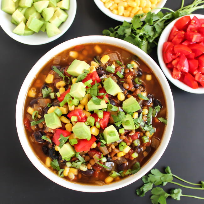 Bowl of vegan lentil taco soup with toppings