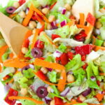 Vegan Italian Chopped Salad in a bowl with wooden utensils