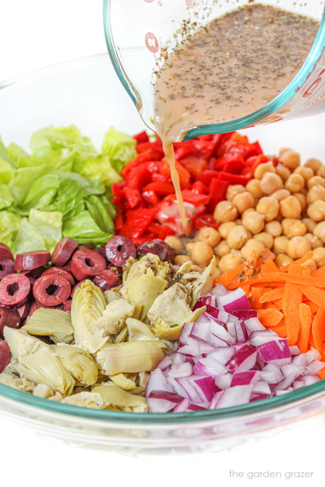 Dressing being poured on ingredients in a bowl