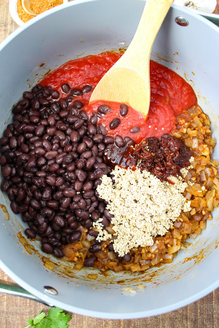 Overhead view of preparing chili ingredients in a large pot before stirring together