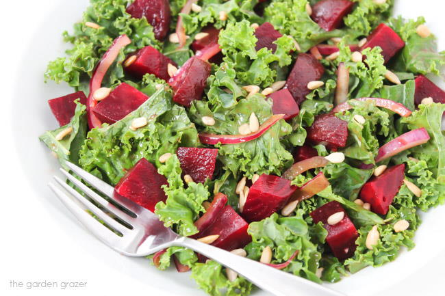 Plate with kale salad with onions, beets, and sunflower seeds
