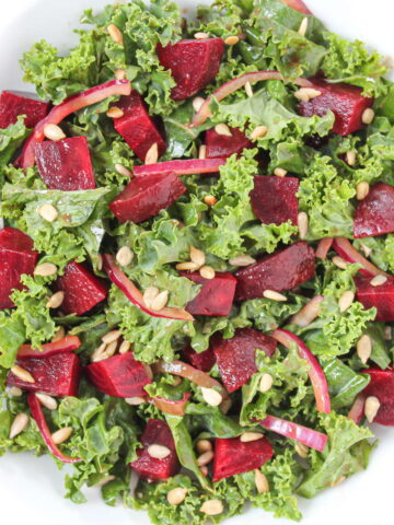 Balsamic roasted beet and kale salad on a white plate