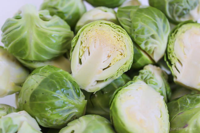 Raw Brussels sprouts cut in half on a cutting board