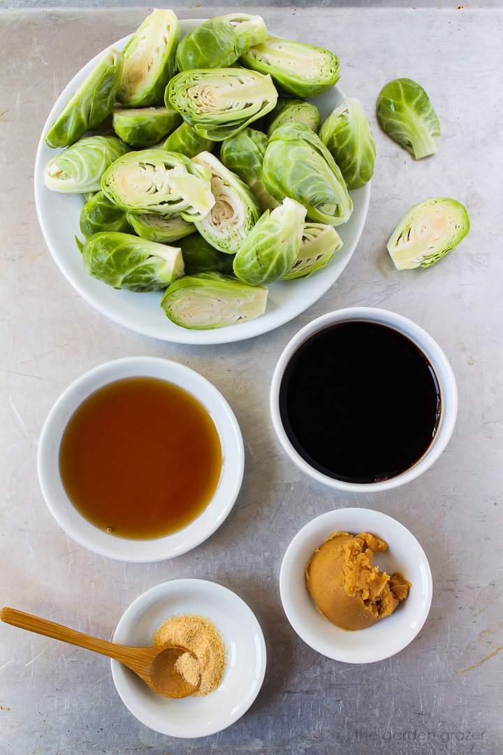 Vinegar, pure maple syrup, garlic powder, and miso ingredients laid out on a metal tray