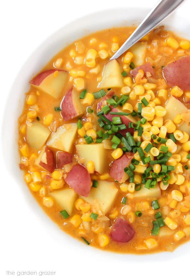 Bowl of vegan corn and potato chowder with a spoon