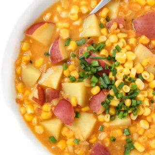 Bowl of vegan corn and potato chowder with a spoon