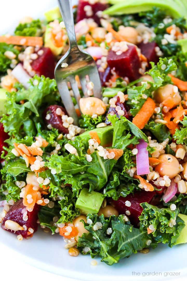 Close-up view of a fork piercing some kale superfood salad