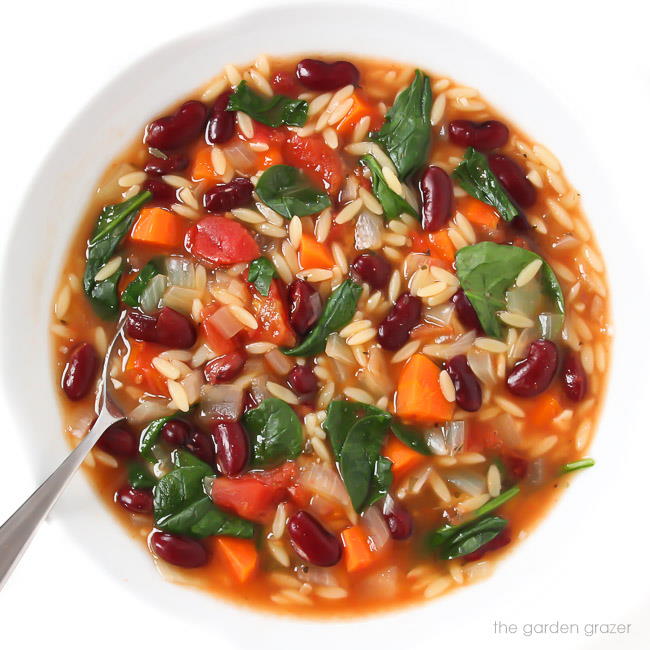 Kidney bean spinach soup in a bowl with spoon
