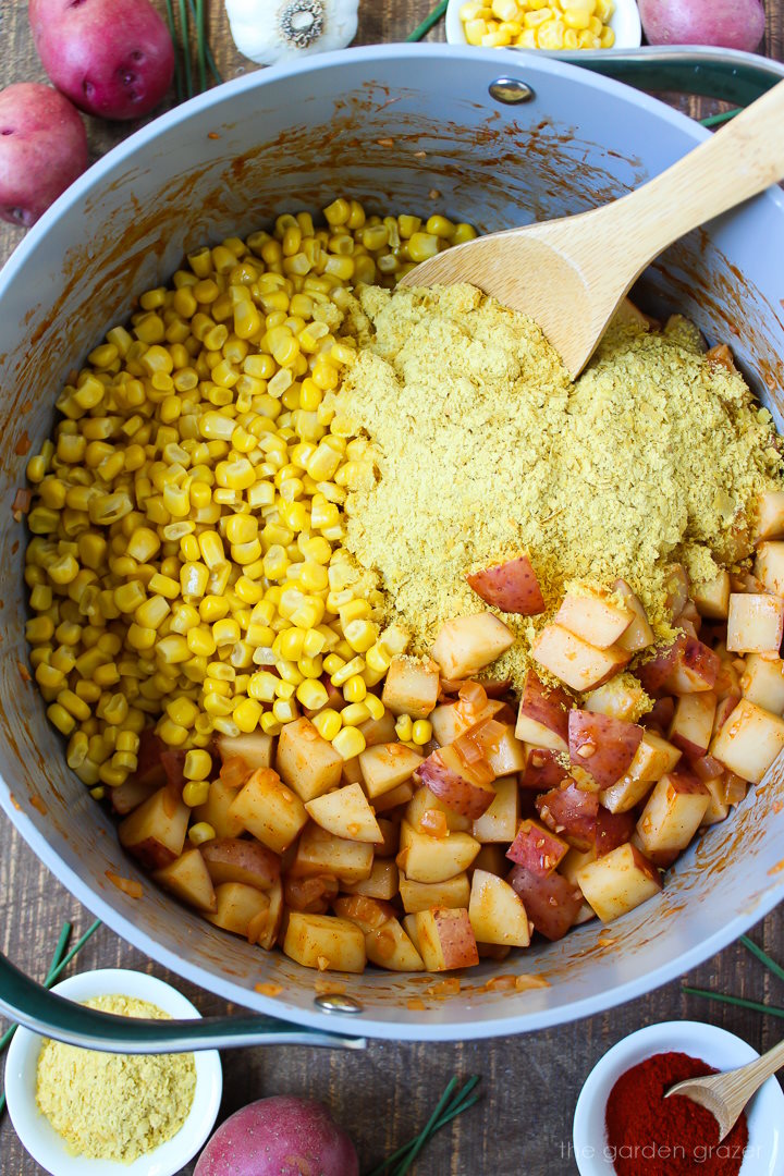 Overhead view of preparing chowder ingredients in a large pot before stirring together