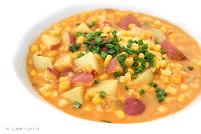 Bowl of corn and potato chowder topped with chives