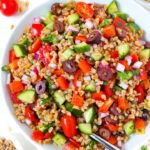 Vegan Greek Farro Salad in a large white bowl with serving spoon