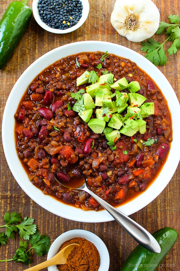 Black lentil chili in a white serving bowl on a wooden table
