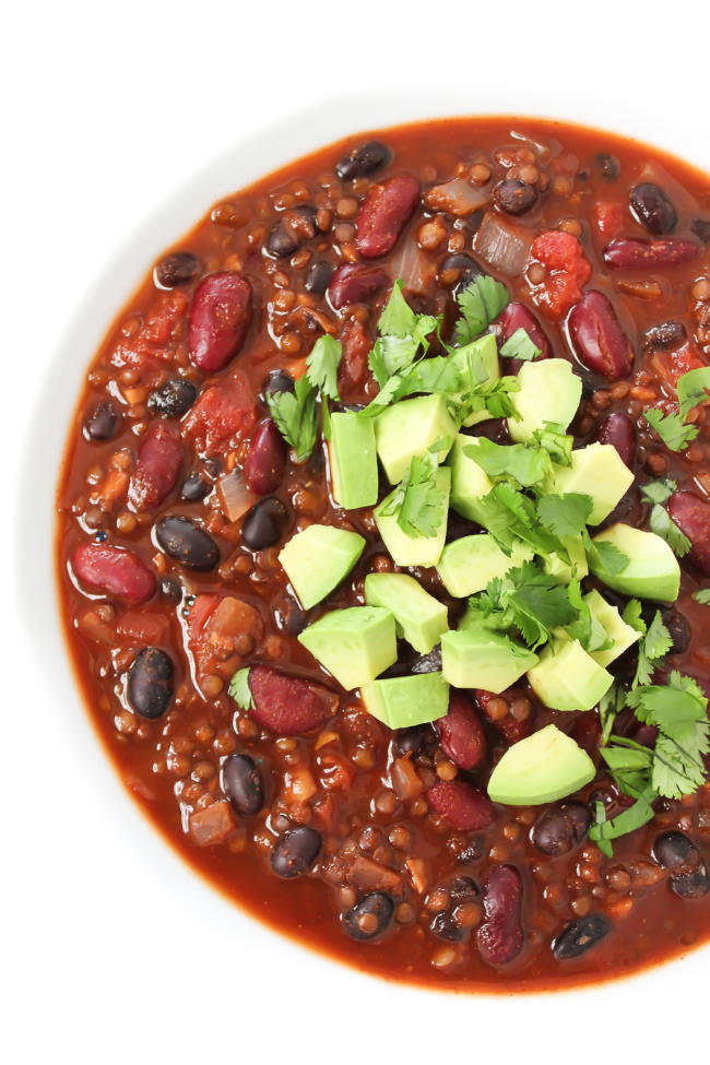 Bowl of vegan chili topped with avocado and cilantro