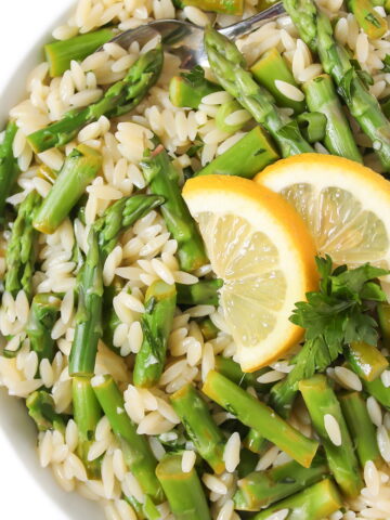 Lemon asparagus orzo with garlic in a white bowl