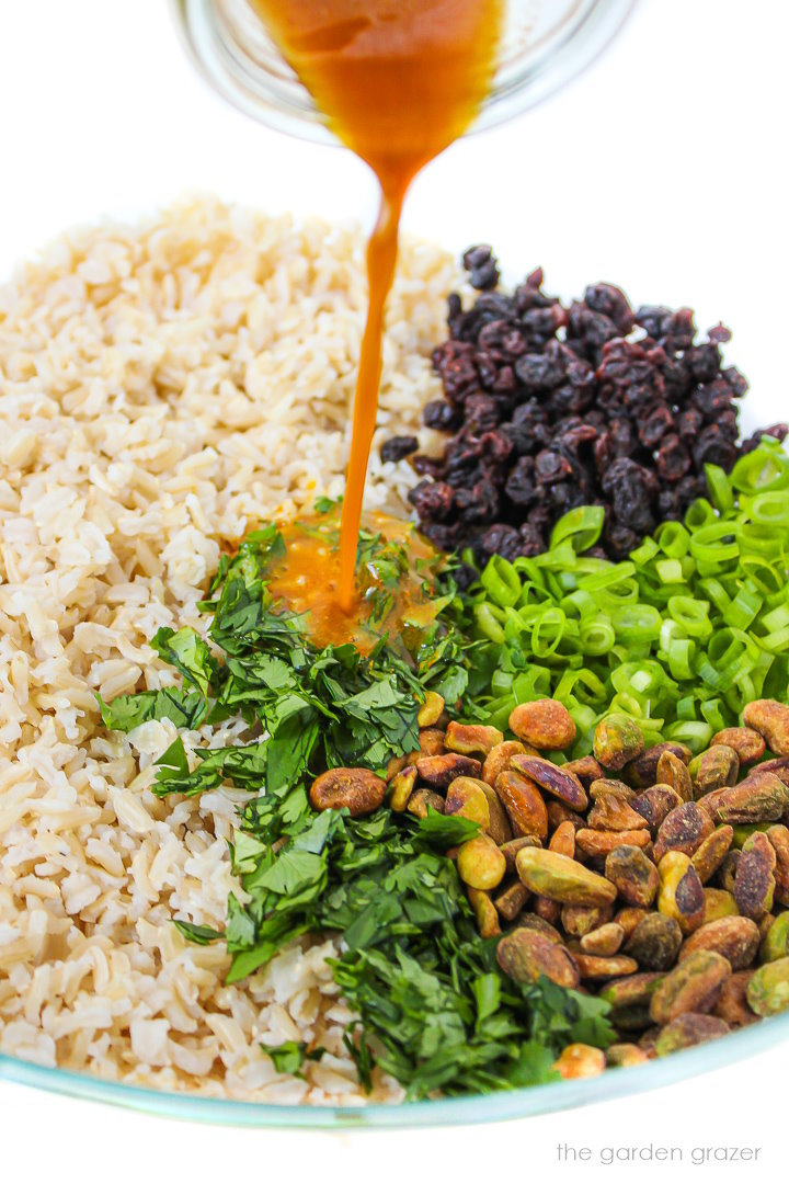 Dressing being poured over the ingredients for curried rice salad