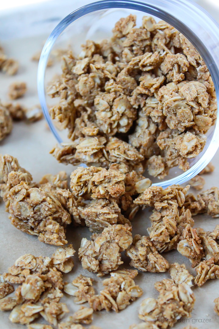 Oil free peanut granola spilling out of a glass jar