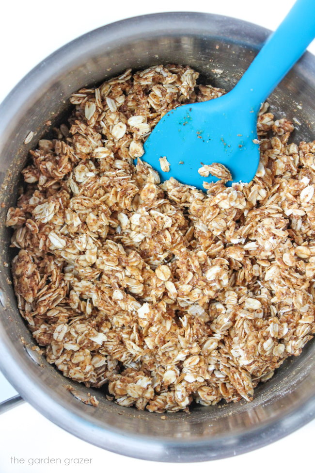 Preparing oil free granola in a small saucepan with spatula 