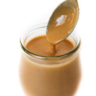 Small glass jar filled with creamy Thai Peanut Sauce